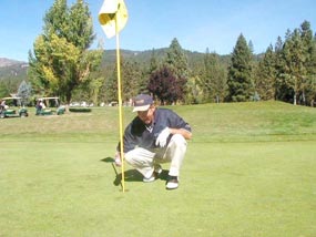 Golfer at flag after hitting a hole in one